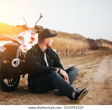 Smiling happy biker in sitting on motorcycle on road