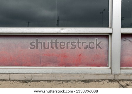 Faded red panels of an abandoned store