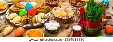 Colored eggs, wheat springs and sweet pastry for Nowruz Holiday in Azerbaijan. Panoramic image. Selective focus.