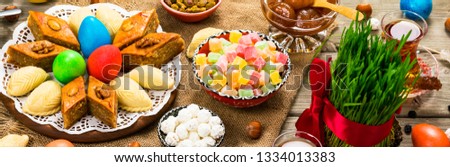 Colored eggs, wheat springs and sweet pastry for Nowruz Holiday in Azerbaijan. Panoramic image. Selective focus.