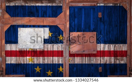Close-up of an old warehouse gate with the national flag of  Cape Verde. The concept of export-import  Cape Verde, storage of goods and national delivery of goods. Flag in grunge style