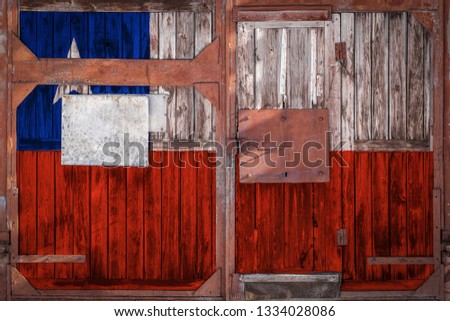 Close-up of old warehouse gate with national flag of Сhile. The concept of export-import Chile, storage of goods and national delivery of goods. Flag in grunge style