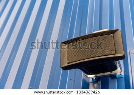 Black speakers on blue steel walls