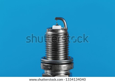 new spark plugs a blue background. Studio macro image of high quality. To advertise auto service.