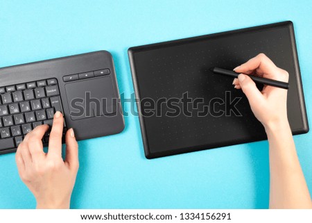 graphics tablet and keyboard on a blue background. Space for text.Keyboard.