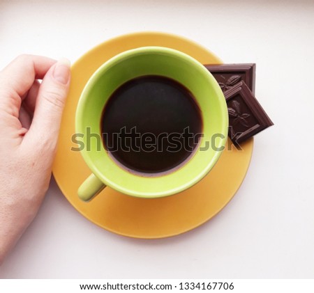 a cup of coffee on saucers with black chocolate