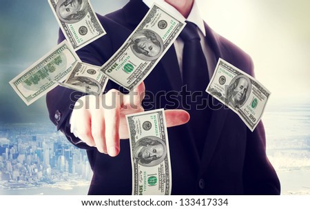 Business man with hundred dollar bills on big city backdrop