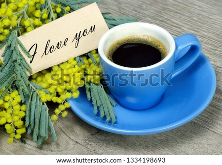 bouquet and a cup of coffee. mimosa flowers and a cup of coffee. coffee and a note i love you. inscription i love you