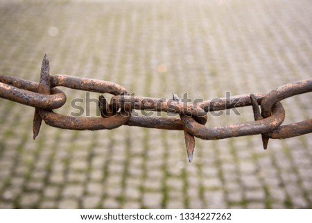 Vintage old and rusty chain link against cobble stone background in copenhagen