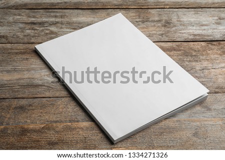 Brochure with blank cover on wooden background. Mock up for design Royalty-Free Stock Photo #1334271326