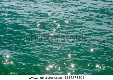 A full frame photograph of sunlight reflecting and shimmering on the ocean