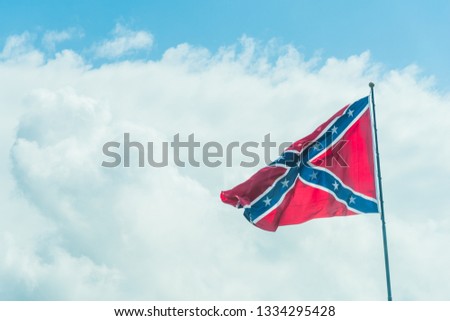 Confederate flag under a blue sky with clouds in Florida, USA