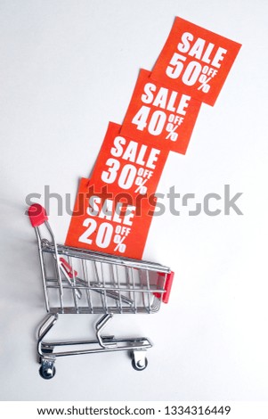 A Trolley with red labels in the form of discounts on a white background. The concept of stock sales. Vertically.