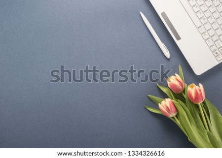 Office table with  keyboard, pen and flowers 