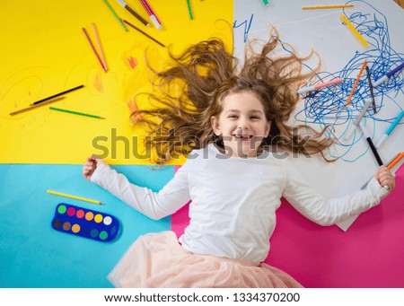 Young girl play and draw with crayons.