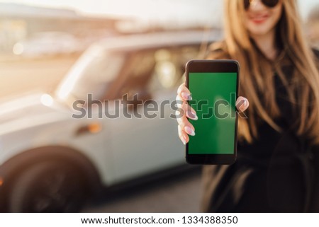 Business woman near car using Smartphone.