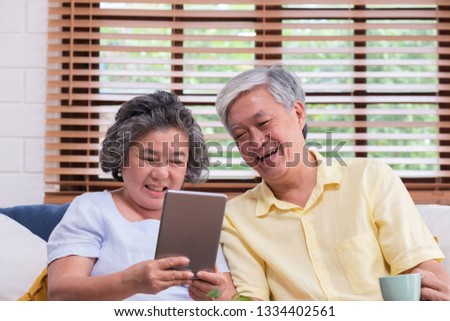 Asian senior couple learn to using table compute on sofa in living room at home.senior with technology lfiestyle.aging at home concept
