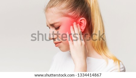 Tinnitus. Profile of sick female having ear pain, touching her painful head, panorama Royalty-Free Stock Photo #1334414867