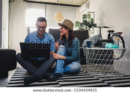 Young Hipster Couple Shopping Online At Home