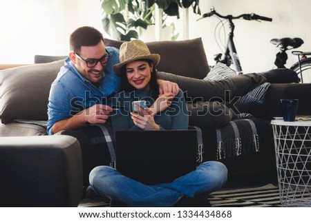 Young Hipster Couple Shopping Online At Home