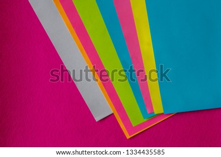 texture of few sheets of coloured paper and fuchsia background