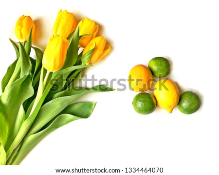 Yellow tulips bouquet and a cup of tea with lemon isolated on white