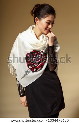 Rich Asian girl in a white silk scarf wearing a flower pattern shot in yellow background