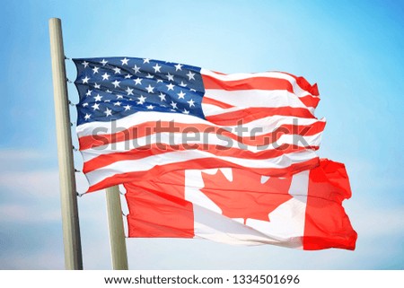 Flag of the USA and Canada against the background of the blue sky