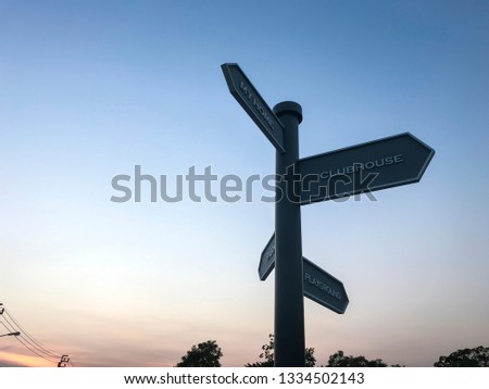 Directional sign post on evening sky.