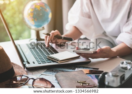 Young traveler planning vacation trip and searching information or booking hotel on laptop, Travel concept Royalty-Free Stock Photo #1334566982