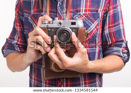 Vintage, photographer and hobby concept - close up of retro camera in man's hands over the white background