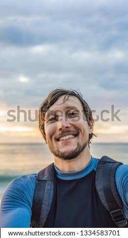 A man takes a selfie on the background of the sea and sunset VERTICAL FORMAT for Instagram mobile story or stories size. Mobile wallpaper Royalty-Free Stock Photo #1334583701
