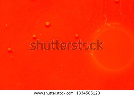 Red and gold colorful paint background in concept rich texture. Colors dropped into liquid and photographed while in motion. abstract composition.