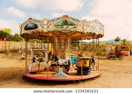 Colorful carousel standing on soil land, looking like abandoned. Royalty-Free Stock Photo #1334585621