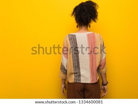 Young african american girl with blue eyes from behind, looking back