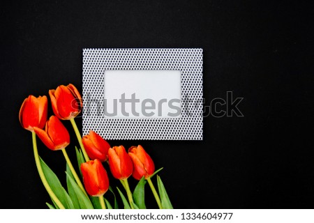 Creative composition with photo frame mock up, red tulips  on abstract  background. Flat lay, top view stylish art concept.