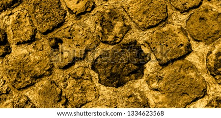 Dark golden ancient bricks of the wall