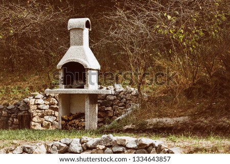 Stone garden oven for grill or barbeque is in a backyard at autumn season