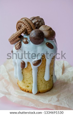 Easter, Easter cake decorated with chocolate and cookies. Traditional Kulich, Easter Bread. Spring holiday in memory of the resurrection of Christ. Pink background.