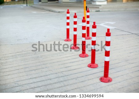 traffic cone, with white and Red stripes on gray concrete road