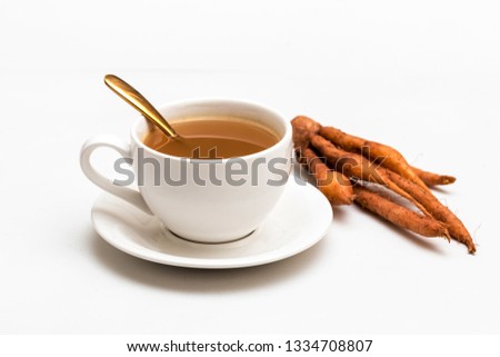 The finger root or Chinese's Ginger is herbal beverage in thailand. white cup and golden spoon with herb in picture.