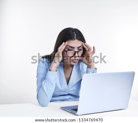 A young woman looking at laptop worried, white background