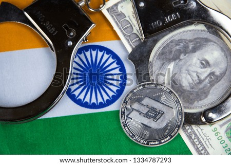 India flag with handcuffs and a bundle of dollars and dash coin. Currency corruption in the country. Financial crimes