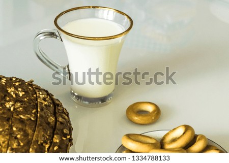 milk in a mug on the table with bread, drying or apples 