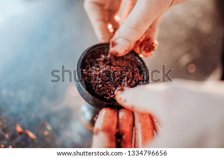 Process of making hookah for smoking. concept of smoking a hookah and having a good time. laying tobacco in a hookah bowl top view with hands Royalty-Free Stock Photo #1334796656