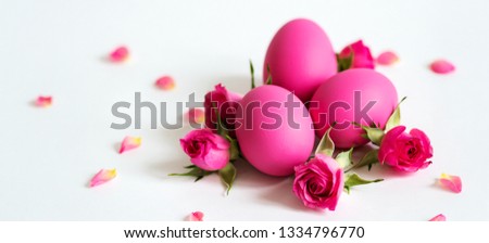 Pink Easter eggs on light background with  pink roses. Long wide banner with copy space.