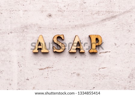 Inscription ASAP as soon as posisioble abbreviation in wooden letters on a light background.