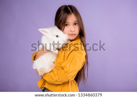 baby girl with Easter Bunny, Easter bunny.A small child in the style of an Easter Bunny playing with an animal. Nice girl and rabbit.Little girl in rabbit ears with Easter Bunny, copy space.