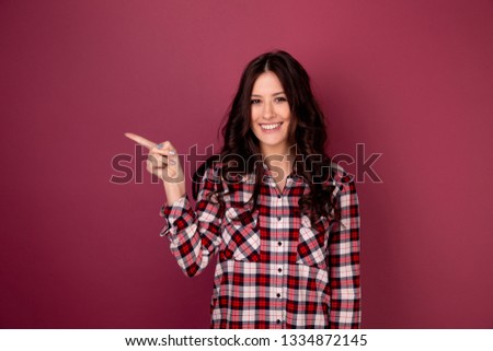 Photo of female person showing her finger up and smiling isolated over the dark pink backgrownd.