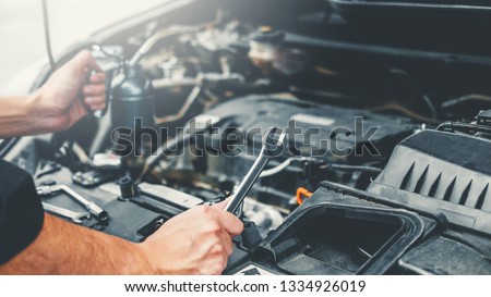 Auto mechanic working in garage Technician Hands of car mechanic working in auto repair Service and Maintenance car check. Royalty-Free Stock Photo #1334926019